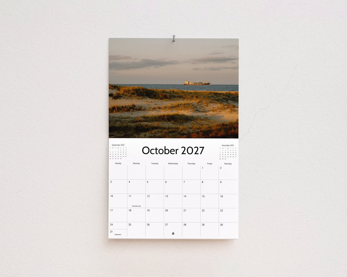 October 2027 page: golden dune grass with a cargo ship on the horizon