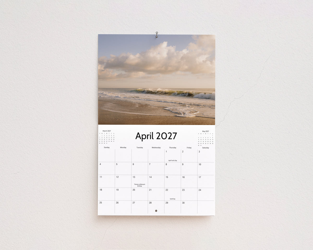 April 2027 page: waves rolling onto the beach under soft white clouds