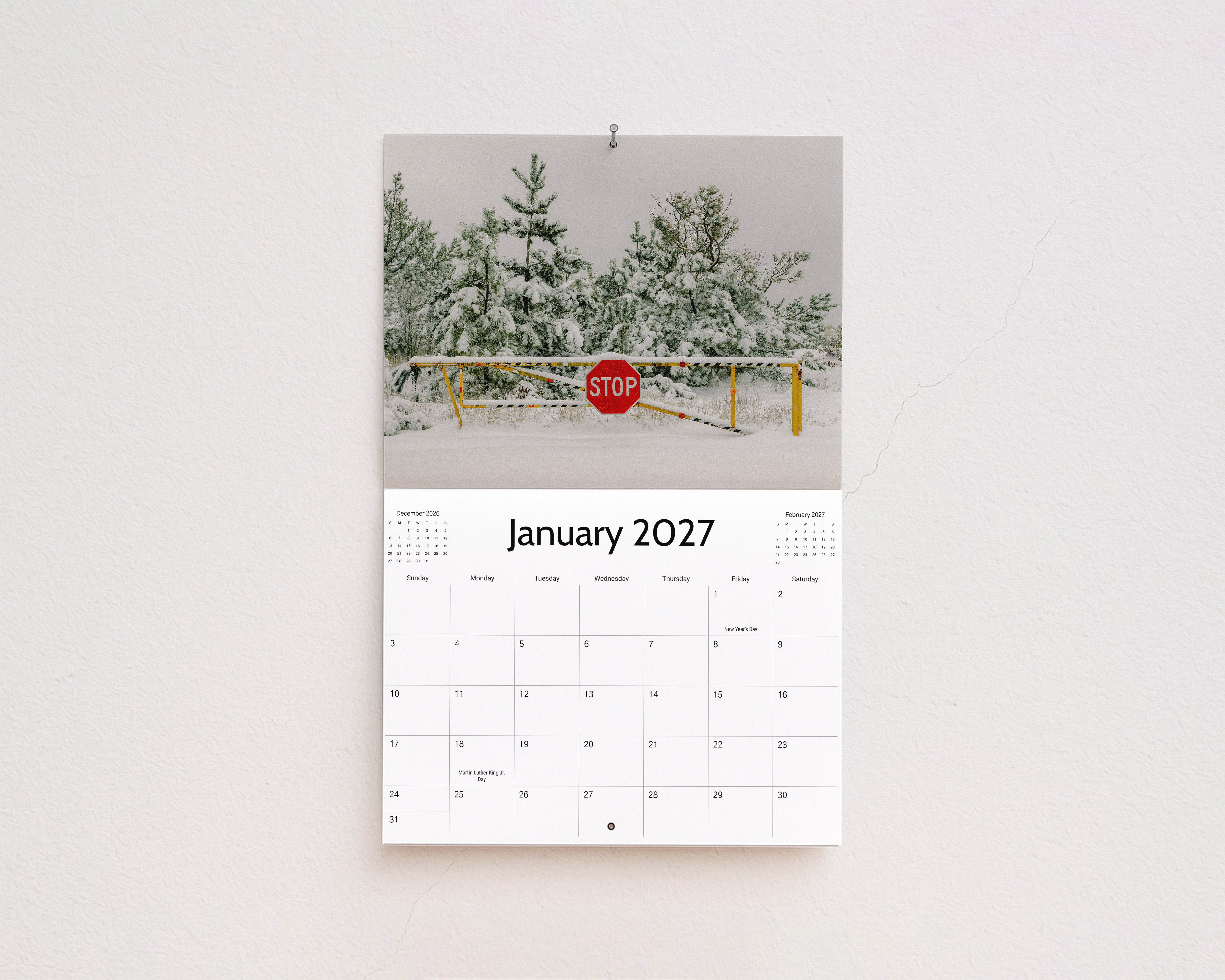 January 2027 page: snow-covered pine trees behind a stop sign and gate