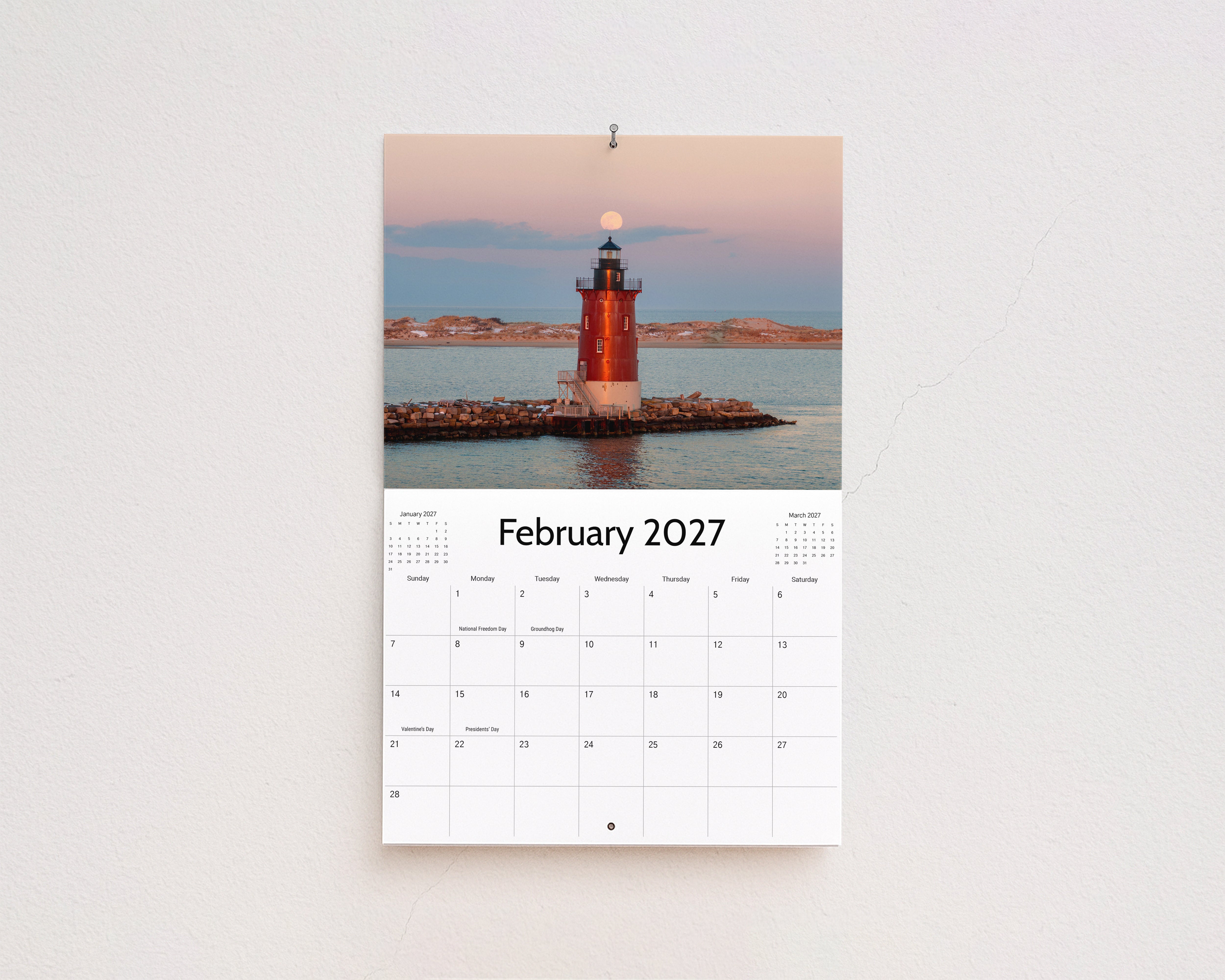 February 2027 page: red lighthouse on a rock jetty with the moon rising at dusk