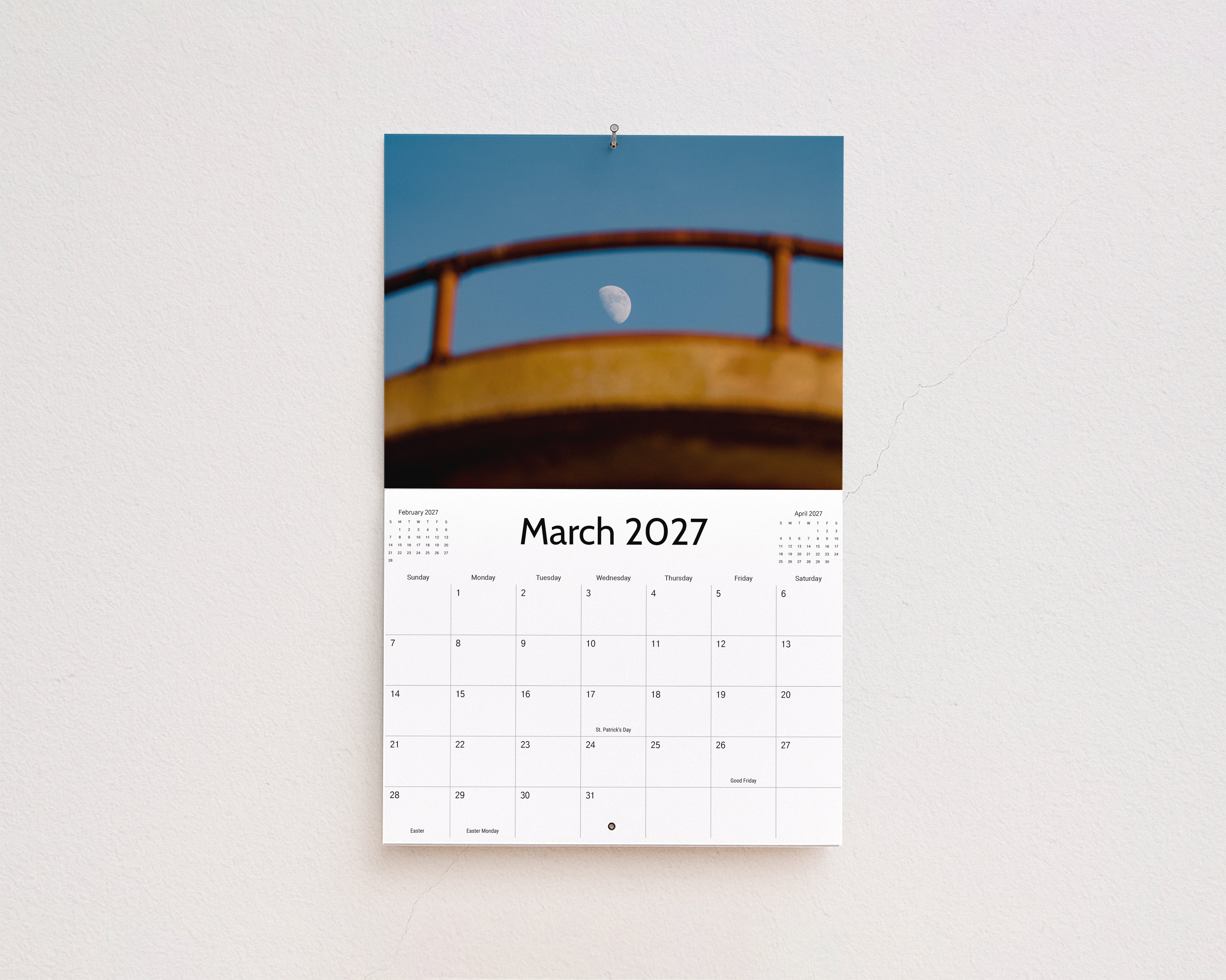 March 2027 page: the moon framed by a weathered yellow railing against a blue sky