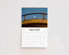 March 2027 page: the moon framed by a weathered yellow railing against a blue sky