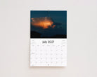 July 2027 page: a glowing orange storm cloud in a dark evening sky